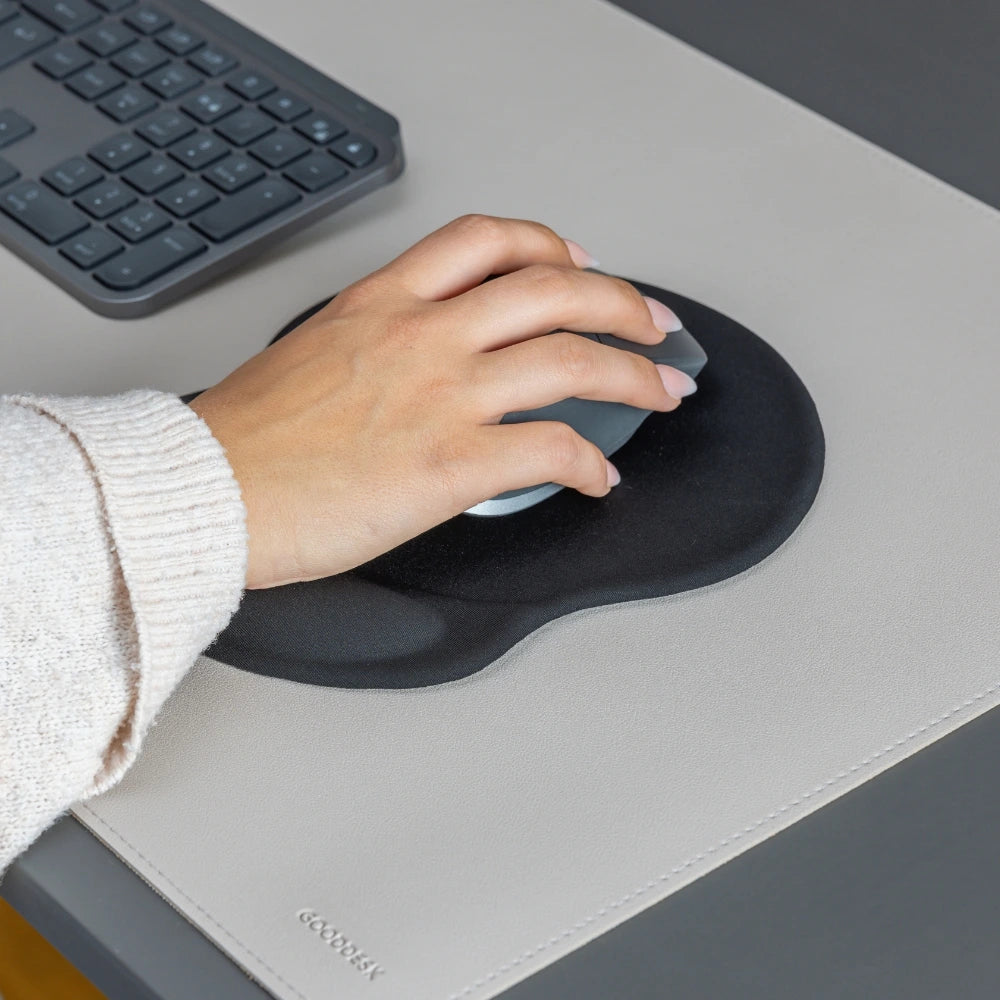 Hand, die eine Maus auf einem ergonomischen ERGOPAD Mauspad mit Handgelenkauflage verwendet. Die Unterlage liegt auf einer hellen GOODDESK Schreibtischunterlage und bietet Komfort und Unterstützung für das Handgelenk bei der Nutzung der Maus.